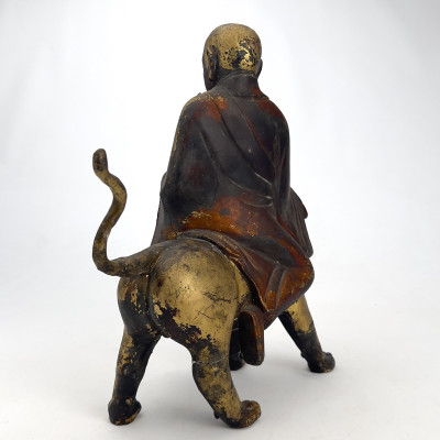 Chinese Polychrome and Parcel-Gilded Wood Figure of a Buddhist Arhat Riding a Lion