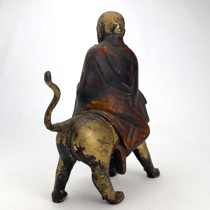 Chinese Polychrome and Parcel-Gilded Wood Figure of a Buddhist Arhat Riding a Lion